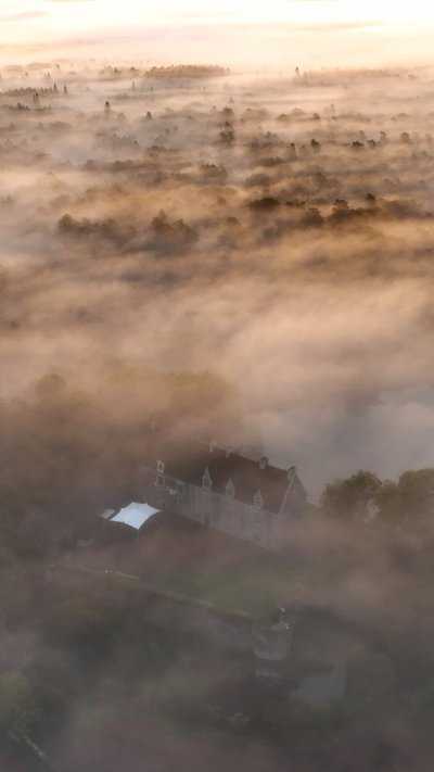 Le château de Comper émergeant de la brume automnale
